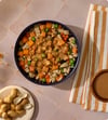 Chicken Peanut Satay bowl of fresh dog food topped with peanut butter drizzle, peas, carrots and sweet potato